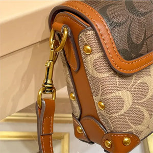 Close-up of the Coach Color Crossbody Handbag showing the gold clasps and detailed stitching on the strap.